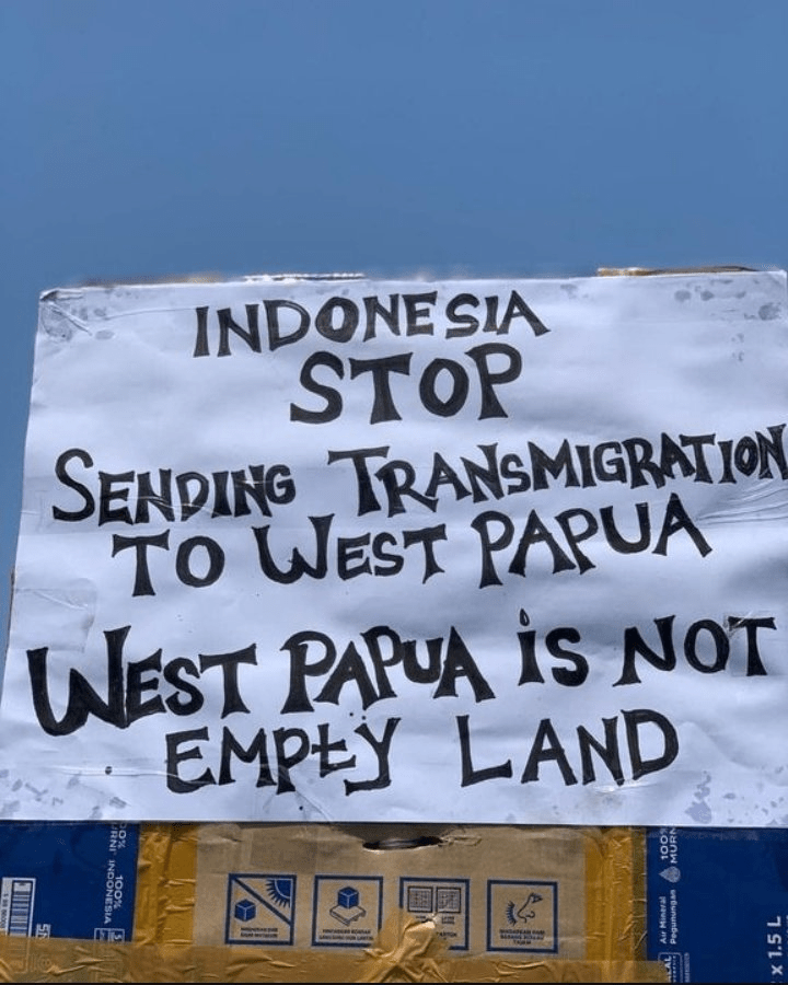 A sign saying 'Stop sending transmigration to West Papua, West Papua is not an empty land'