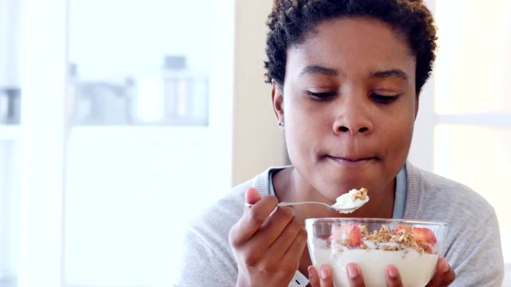 Palm oil free breakfast cereal - a woman enjoying granola