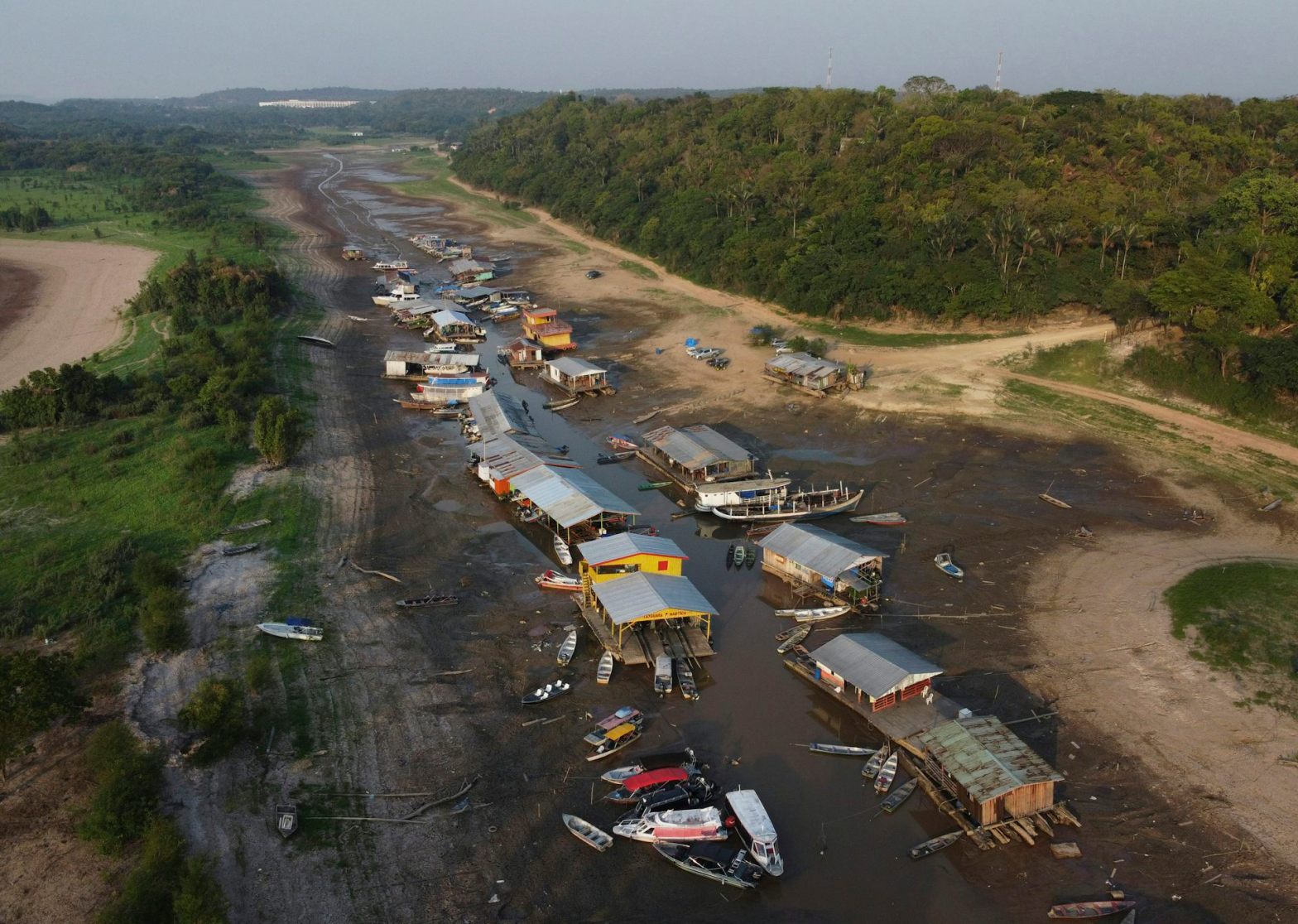 “Traffic jams” of boats and floating houses on the dry bed of Lake Puraquequara, in the outskirts of Manaus: a combination of climate change, a strong El Niño and insistence on works with a huge environmental impact contribute to an unprecedented and extremely urgent condition in the region. AP Photo/Edmar Barros
